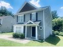 Corner view of gray home with black shutters, featuring landscaping and a Ring doorbell at 5908 Abbington Way, Raleigh, NC 27610