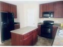 Spacious kitchen with cherry wood cabinets, black appliances, and a center island at 5908 Abbington Way, Raleigh, NC 27610