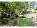 Serene backyard featuring mature trees, a manicured lawn, and a cozy seating area at 6412 Forest Ridge Dr, Durham, NC 27713