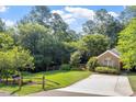Inviting home with a well-kept lawn, mature trees, and a charming wooden fence at 6412 Forest Ridge Dr, Durham, NC 27713