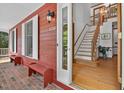 Entrance to a red home showing the foyer with hardwood floors and stairs at 6728 Glen Forrest Dr, Chapel Hill, NC 27517