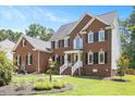 Beautiful brick house with well-manicured lawn, and white stair railing at 8512 Barrett Hall Ln, Wake Forest, NC 27587