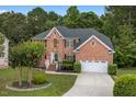 Beautiful brick home with well-manicured lawn, mature tree, and two-car garage at 9 Monteith Ct, Durham, NC 27713