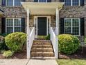 Inviting front entrance with brick steps, white railings, and lush landscaping at 1035 Evening Shade Ave, Rolesville, NC 27571