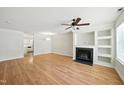 Bright living room with hardwood floors, ceiling fan, fireplace, and built-in shelving perfect for entertaining at 110 Virens Dr, Cary, NC 27511