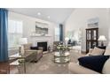Bright living room with a fireplace, plush seating, and large windows at 11571 Auldbury Way, Raleigh, NC 27617