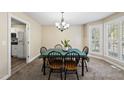 Cozy dining room features natural lighting, carpeted floors, and a modern chandelier at 116 Hidden Cellars Dr, Holly Springs, NC 27540