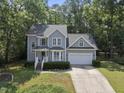 Charming two-story home with attached garage, manicured landscaping, and mature trees at 116 Hidden Cellars Dr, Holly Springs, NC 27540
