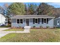 Charming single-story home with blue siding, black shutters, and a neatly landscaped front yard at 1203 Freeman Dr, Sanford, NC 27330