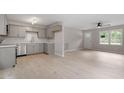 Open-concept kitchen featuring gray cabinets, subway tile backsplash, and stainless steel appliances at 1203 Freeman Dr, Sanford, NC 27330