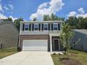 Home featuring a gray exterior, black shutters, brick accents, and a two-car garage at 126 N Keatts Winner Ct, Wilson's Mills, NC 27520