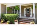 Inviting front porch with decorative plants, brick steps, and a classic front door with glass panels at 149 Hadley Ln, Clayton, NC 27527