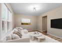 Bright living room features a modern white sofa, wood floors, and neutral decor, perfect for relaxing at 1611 Poole Rd, Raleigh, NC 27610