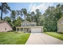 Charming two-story home with a well-maintained lawn, inviting front porch, and a two-car garage at 1909 Piperwood Ct, Durham, NC 27713