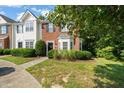 View of charming townhome showcasing brick and siding facade, green lawn, and mature landscaping at 2833 Gross Ave, Wake Forest, NC 27587