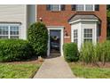 Close-up of townhome's front door with black trim, decorative wreath, and well-maintained landscaping at 2833 Gross Ave, Wake Forest, NC 27587