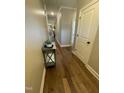 Hallway with hardwood floors, white trim, and neutral paint, leading to other rooms at 3 Meadowrue Ln, Youngsville, NC 27596