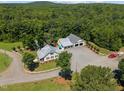 Aerial view showcasing a charming home, spacious garage, and lush greenery on a sprawling estate at 4050 Culbreth Rd, Stem, NC 27581