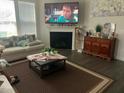 A cozy living room with a fireplace, a large screen television, and a comfortable seating area at 4108 Cross Timber Ln, Raleigh, NC 27603