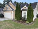 Home with well-maintained lawn, garden beds and mature evergreens at 421 Braxman Ln, Holly Springs, NC 27540