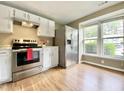 Bright kitchen boasts white cabinets, stainless steel appliances, and wood-look flooring at 4324 Halliwell Dr, Raleigh, NC 27606
