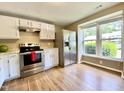 Bright kitchen features stainless steel appliances, white cabinets and a large window at 4324 Halliwell Dr, Raleigh, NC 27606
