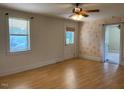 Bright living room with hardwood floors, ceiling fan, and a door to the outside at 462 Ashland Dr, Goldston, NC 27252