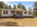 Single-story home with red shutters, a covered front porch, and mature trees at 51 Brafford Estates Dr, Cameron, NC 28326