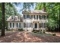 Charming two-story home with black shutters, a brick chimney, and mature landscaping at 5113 Linksland Dr, Holly Springs, NC 27540