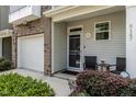 Inviting front entry featuring a cozy sitting area and attached garage with brick accent at 6147 Beale Loop, Raleigh, NC 27616