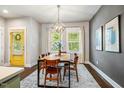 Open dining room with modern light fixture, wood table, and a gray accent wall at 644 Granite Mill Blvd, Chapel Hill, NC 27516