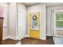 Bright entryway featuring a yellow front door, wood floors, white trim, and natural light at 644 Granite Mill Blvd, Chapel Hill, NC 27516