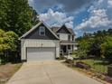 A charming two-story home with a two-car garage, beautiful landscaping, and a spacious driveway at 723 Lindley Dr, Durham, NC 27703