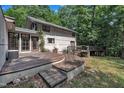 Backyard featuring a wooden deck with unique bridge and stone paver steps leading to a grassy lawn at 8510 Dunlee Falls Rd, Raleigh, NC 27613