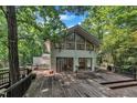 Modern home exterior showing a spacious wooden deck and contemporary design, nestled among trees at 8510 Dunlee Falls Rd, Raleigh, NC 27613