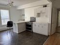 Kitchen with white cabinets, tile backsplash, and modern appliances at 903 New Bern Ave, Raleigh, NC 27601