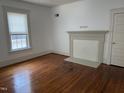 Bright living room featuring hardwood floors, fireplace, and natural light from a window at 903 New Bern Ave, Raleigh, NC 27601