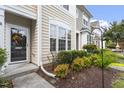 Charming townhouse exterior featuring manicured landscaping, lush bushes and covered entrance at 109 Grey Elm Trl, Durham, NC 27713