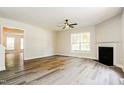 Bright living room featuring wood floors, a fireplace, and a ceiling fan at 114 Seastone St, Raleigh, NC 27603