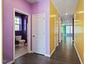 Hallway with doors leading to different rooms, purple and yellow walls at 136 Durie Way, Garner, NC 27529