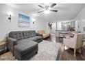 Open living room with a ceiling fan, a gray sofa, and a view into the kitchen at 1851 Trailwood Heights Ln # 201, Raleigh, NC 27603