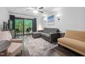Bright living room featuring a neutral color palette, sliding glass door to balcony, and hardwood floors at 1851 Trailwood Heights Ln # 201, Raleigh, NC 27603