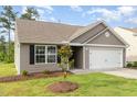 Single story home featuring neutral siding, a two-car garage, and a well-manicured lawn at 2040 Alderman Way, Creedmoor, NC 27522