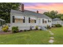 Charming home with manicured landscaping, white exterior paint, awnings, and a inviting entrance at 2129 Wrenn St, Burlington, NC 27215