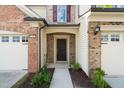 Close-up of front door with brick and siding, plus well-maintained landscaping at 236 Lynchwick Ln, Durham, NC 27703