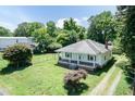 This charming home is surrounded by mature trees and has a spacious yard, partially fenced, with a long driveway at 310 Spring St, Durham, NC 27703