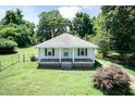 A charming single-story home with a covered front porch, and a spacious yard surrounded by mature trees at 310 Spring St, Durham, NC 27703
