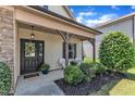 Inviting front porch featuring decorative wreath, seating area, and well-maintained landscaping for a welcoming entrance at 3106 Royal Deeside Ct, Zebulon, NC 27597