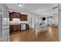 Open-concept kitchen featuring hardwood floors, stainless steel appliances, adjacent dining area, and seamless flow to the living room at 3106 Royal Deeside Ct, Zebulon, NC 27597