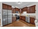Spacious kitchen featuring stainless steel appliances, hardwood floors, and ample dark wood cabinetry at 3106 Royal Deeside Ct, Zebulon, NC 27597